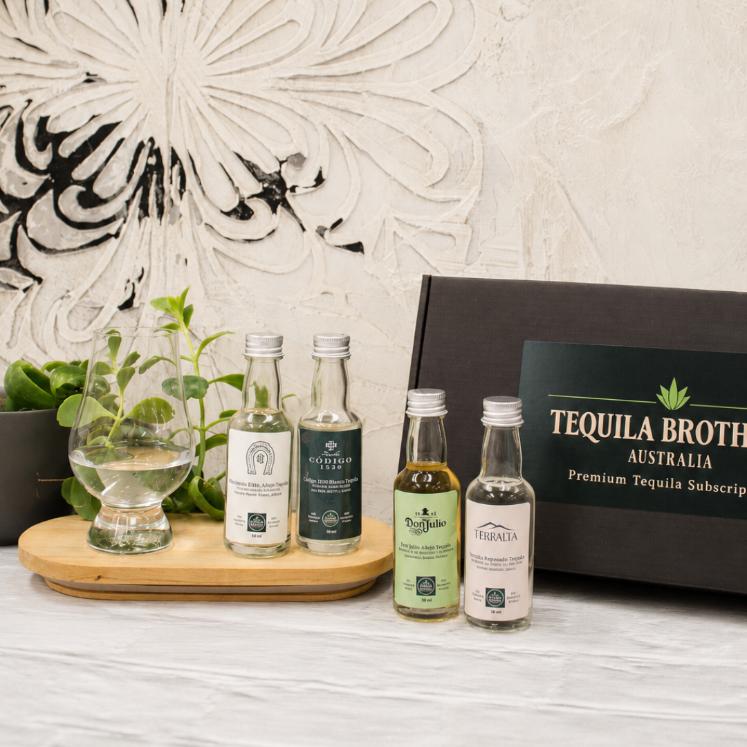 Four tequila bottles on a wooden tray with a decorative wall and 'Tequila Brothers Australia' box in the background.