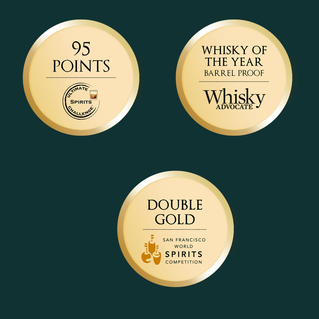 A close-up image of three gold colored award labels for whiskey. The labels are arranged vertically. The top label displays “95 POINTS WHISKY OF THE YEAR” in black text. The middle label displays “ULTIMATE SPIRITS CHALLENGE DOUBLE GOLD” in black text. The bottom label displays “SAN FRANCISCO WORLD SPIRITS COMPETITION” and “DOUBLE GOLD” in black text. All three labels have a green background.